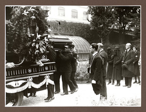 La bara viene collocata sul carro funebre