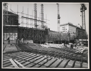 Uomini al lavoro durante una fase della costruzione della Nuova Sede: sul fondo l'Hotel Excelsior Gallia