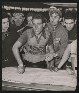 XLIV edizione del Giro di Lombardia disputatosi il 22 ottobre 1950: la manifestazione vide la vittoria di Renzo Soldani, che corse con la squadra Legnano, seguito da Antonio Bevilacqua della Wilier-Triestina e da Fausto Coppi della Bianchi-Ursus. Renzo Soldani con i membri della squadra dietro a un tavolo su cui è appoggiato il foglio Firma Arrivo&quot;: l'immagine è stata pubblicata dalla rivista &quot;Pirelli (anno III, n. 6, dicembre 1950, p. 39)