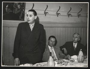 Il direttore della filiale padovana della Pirelli, Arrigo Daveglia, si sta alzando dal tavolo: accanto a lui, ancora seduti, si trovano Alfredo Binda e un'altra persona
