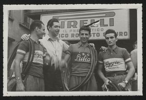 Distribuzione dei tubolari presso La Gazzetta dello Sport: un uomo insieme a tre corridori, uno dei quali (il primo da destra) è Enrico Gandolfi, vincitore della corsa eliminatoria veneta