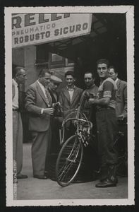 Distribuzione dei tubolari presso La Gazzetta dello Sport: un corridore che ha ricevuto i tubolari, insieme ad altri uomini, uno dei quali è Alfredo Binda