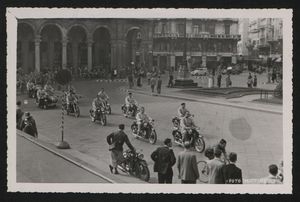 Il passaggio dei ciclisti e dei motociclisti al seguito in piazza del Duomo a Milano