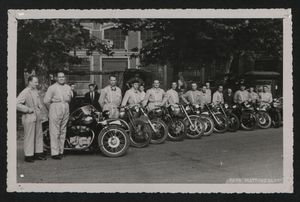 Un gruppo di uomini con motocicli e sidecar: si tratta probabilmente dei motociclisti che precedono o seguono i corridori ciclisti nel corso del corteo o della gara