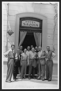 Un gruppo di persone, probabilmente organizzatori della corsa e membri della giuria, di fronte all'hotel Savoia, situato probabilmente a Bordighera: tra di esse vi è anche Alfredo Binda
