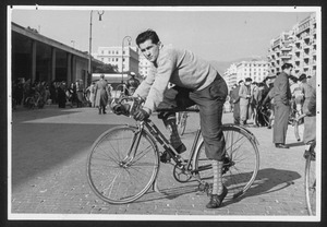 Il corridore Edilio Vanni, vincitore della corsa eliminatoria ligure, ripreso in sella alla bicicletta in una piazza