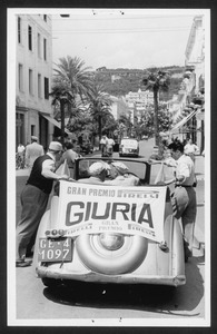 Un'auto a cui è attaccato un manifesto con la scritta: Gran Premio Pirelli Giuria
