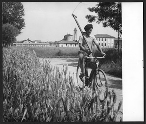 Un ragazzo in sella a una bicicletta su una strada di campagna