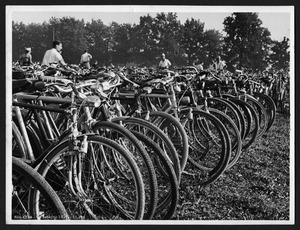 Numerose biciclette e alcune persone in un campo