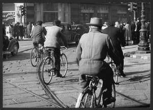 Il passaggio di alcune persone in bicicletta tra piazza Cordusio e via Broletto