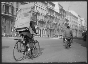 Un uomo trasporta in bicicletta una lastra in vetro