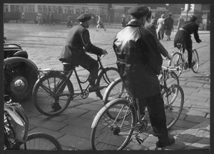 Il passaggio di uomini in bicicletta in una strada cittadina