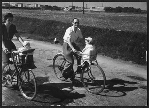 Un uomo e una donna in sella a biciclette con seggiolini per bambini