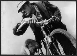 Un uomo con una bicicletta e una pecora