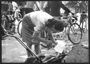 Una donna con un bambino: la fotografia è forse eseguita duranta una gita in bicicletta fuori città
