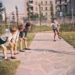 Bambini che giocano alle piastre in un parco giochi, probabilmente quello del Villaggio Pirelli di Cinisello Balsamo. La foto è stata utilizzata per il catalogo dei giocattoli del 1957, impaginato da Bob Noorda.
