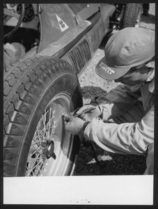 Un tecnico del Servizio Corse Pirelli al lavoro su un'Alfa Romeo: l'immagine è stata pubblicata dalla rivista Pirelli (anno III, n. 5, settembre-ottobre 1950, p. 29)