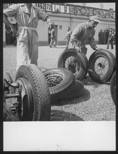 Tecnici del Servizio Corse Pirelli al lavoro fuori dai box: l'immagine è stata pubblicata dalla rivista Pirelli (anno III, n. 5, settembre-ottobre 1950, p. 27)