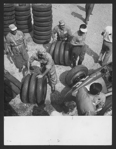 Tecnici del Servizio Corse Pirelli sistemano gli pneumatici Stelvio Nylon utilizzati per la corsa: è riconoscibile l'Alfa Romeo 158 (n. 36) di Luigi Fagioli.