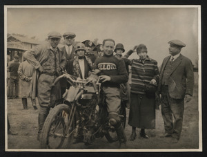 Il pilota Augusto Rava su Moto Galloni, insieme ad altre persone, probabilmente prima dell'inizio di una corsa. L'azienda Moto Galloni, fondata da Alberto Galloni nel 1914 nel comune di Borgomanero (NO), proseguì l'attività fino al 1932
