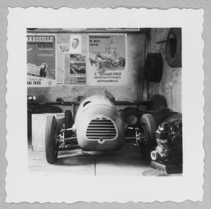 Un'automobile Simca-Gordini T8 nel garage e officina dell'Equipo Argentino: alla parete sono appesi manifesti di corse automobilistiche disputatesi nel 1949 (Gran Premio di Marsiglia, Gran Premio di Sanremo, Gran Premio di Perpignan)