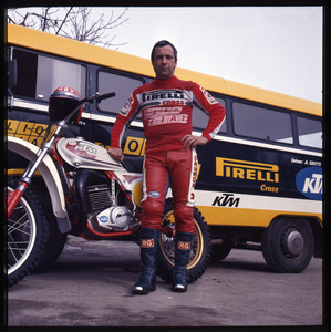 Il pilota Alessandro Gritti, su motocicletta KTM, davanti a un pullman della squadra Pirelli-Magneti Marelli-Olio Fiat