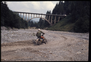 Un momento di una gara motociclistica: il passaggio di un pilota sotto il ponte sul torrente Valeggia a Rovetta (BG)