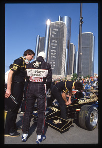 Il pilota Elio De Angelis insieme ai meccanici: in secondo piano sono visibili i grattacieli del Renaissance Center di Detroit