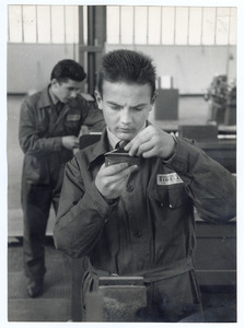 Un allievo controlla un pezzo nell'officina. La fotografia è pubblicata nell'articolo L'Istituto Piero Pirelli in Pirelli. Rivista d'informazione e di tecnica, n.6, 1958, p. 50