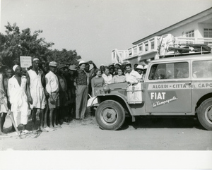 Un gruppo di persone posa accanto a una Fiat Campagnola gommata Pirelli, con adesivo [...] AND RETURN sul lato destro della carrozzeria durante il Raid Algeri - Città del Capo del 1952