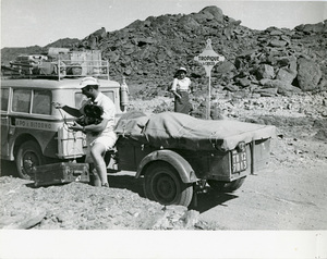 L'operatore cinematografico della Incom Aldo Pennelli con una donna accato alla Fiat Campagnola usata durante il Raid Algeri - Città del Capo del 1952. Alle spalle della donna un cartello TROPIQUE du CANCER.