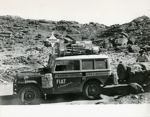 Una donna dietro la Fiat Campagnola usata durante il Raid Algeri - Città del Capo del 1952, accanto al cartello TROPIQUE du CANCER