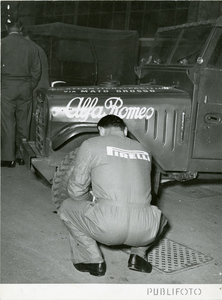 Un meccanico Pirelli controlla le gomme dell'Alfa Romeo per il Raid del Mato Grosso del 1952