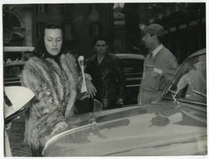L'attrice Elli Parvo e un meccanico Pirelli accanto a un'auto durante il passaggio delle vetture partecipanti al Rally di Monte Carlo del 1954