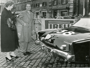L'attrice Milly Vitale e il fondatore della INCOM (Industria CortiMetraggi) Sandro Pallavicini accanto alla vettura 138 del Rally di Monte Carlo 1954, una Studebaker Commander. Sullo sfondo, uno striscione pubblicitario con logo Pirelli.