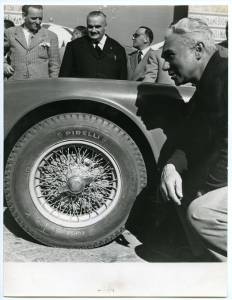 Il pilota Piero Taruffi accanto a una vettura gommata Pirelli durante la Mille Miglia del 4 maggio 1952. In primo piano il pneumatico Corsa.