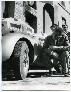 Il pilota Clemente Biondetti  accanto a una vettura gommata Pirelli durante la Mille Miglia del 4 maggio 1952.