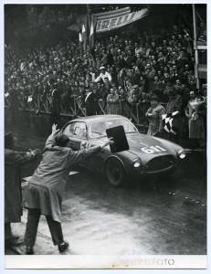 Giovanni Bracco e Alfonso Rolfo a bordo della Ferrari 250 S n. 611 supera il traguardo della Mille Miglia del 4 maggio 1952. In secondo piano, sopra gli spalti, uno striscione pubblicitario Pirelli. L'immagine è stata pubblicata da Fatti e Notizie (anno III, n. 5, maggio 1952, p. 3)