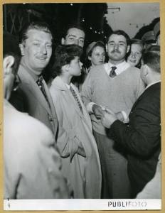 Il vincitore Gianni Marzotto circondato da un gruppo di uomini e donne alla Mille Miglia del 25-26 aprile 1953