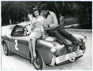 Gli attori Magali Noël e Roberto Risso leggono il regolamento del IV Rally automobilistico del cinema del 1957, seduti sulla Fiat TV n. 2 con la quale partecipano alla manifestazione