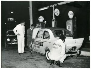 Un team di meccanici controlla una Fiat 500 logata Quattroruote a un distributore Shell, durante il Raid Fiat 500 disputatosi tra il 18 marzo e l'8 giugno 1958