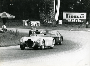 Tre vetture fotografate durante una competizione automobilistica. Si riconoscono le auto dei piloti Gigi Villoresi e Felice Bonetto. A bordo pista, un cartellone pubblicitario Pirelli Stelvio.