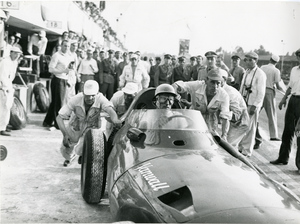 Driver Stirling Moss in Vanwall no. 18 pushed by a team of mechanics during the Italian Grand Prix held in Monza on 8 September 1957
